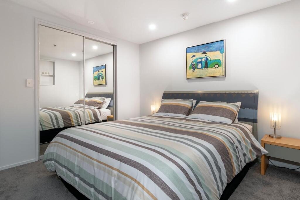 Bedroom with queen bed and mirrored wardrobe