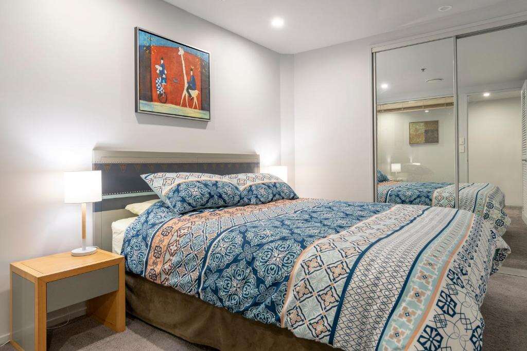 Second bedroom with queen bed and bedside lamp